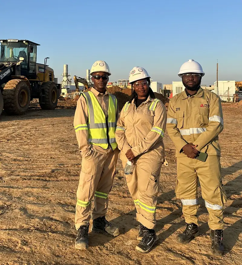 Site workers in PPE beside heavy plant equipment